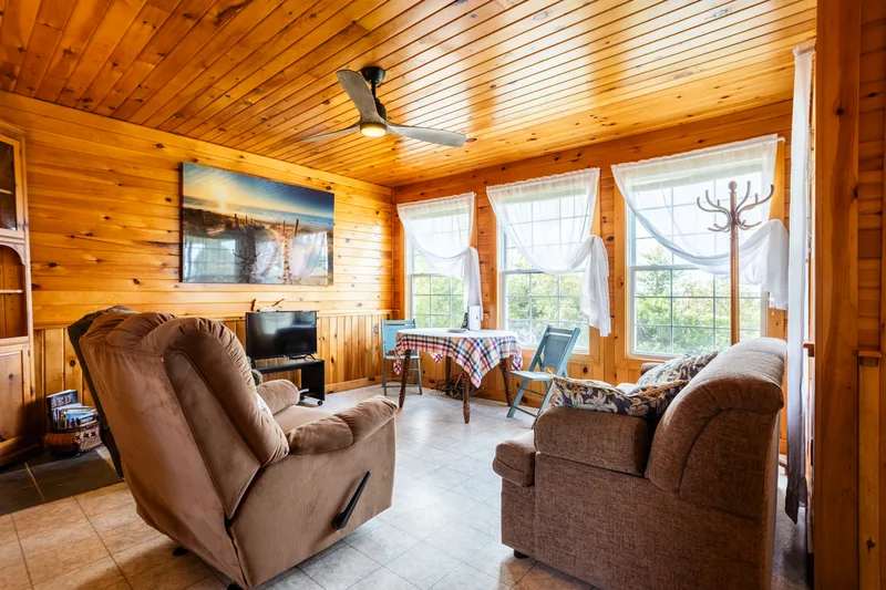 Living and dining area with wood walls