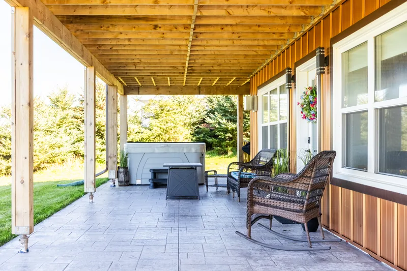 Covered patio with seating and hot tub