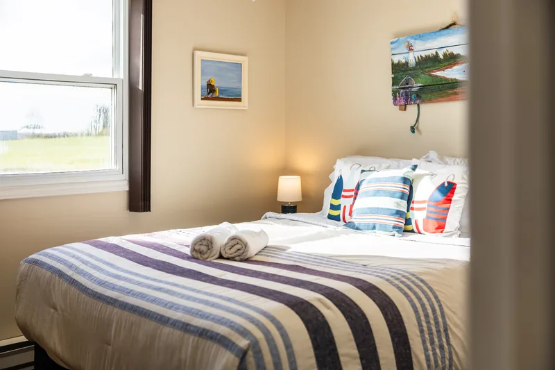 Bedroom with coastal artwork and striped bedding
