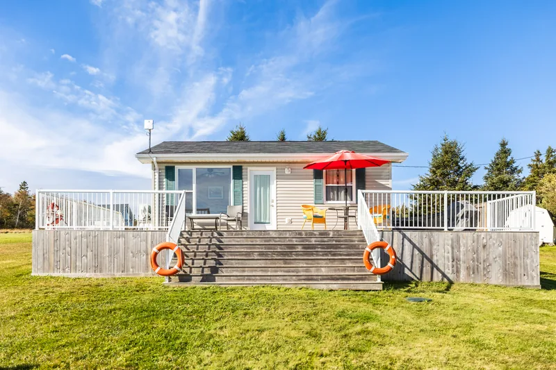 Cottage exterior with red umbrella and deck